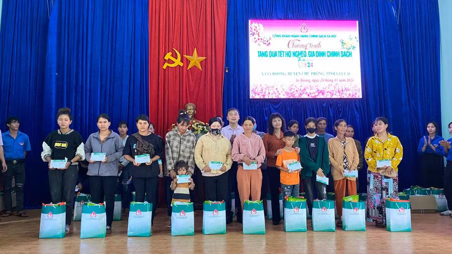 Bà Rơcom Sa Duyên-Giám đốc Sở Lao động Thương binh- Xã hội tỉnh và ông Lê Giang Long-Ủy viên BTV, Chánh văn phòng Công đoàn NHCSXH VIệt Nam trao quà Tết cho bà con. Ảnh: Sơn Ca.