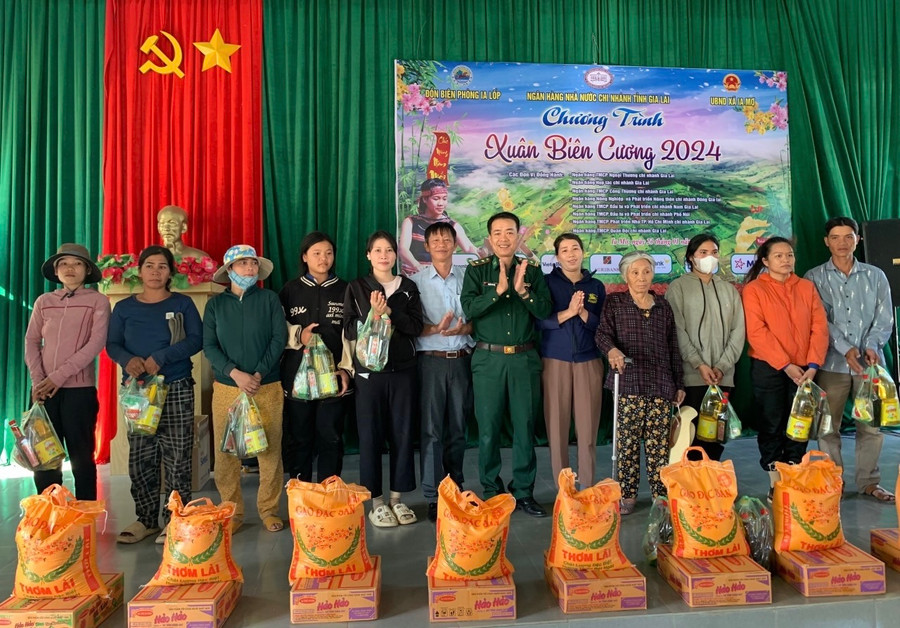 Ông Đặng Văn Sống – Phó Giám đốc, Chủ tịch CĐCS NHNN Chi nhánh tỉnh Gia Lai trao quà Tết cho các gia đình tại xã Ia Mơ. Ảnh: Sơn Ca.