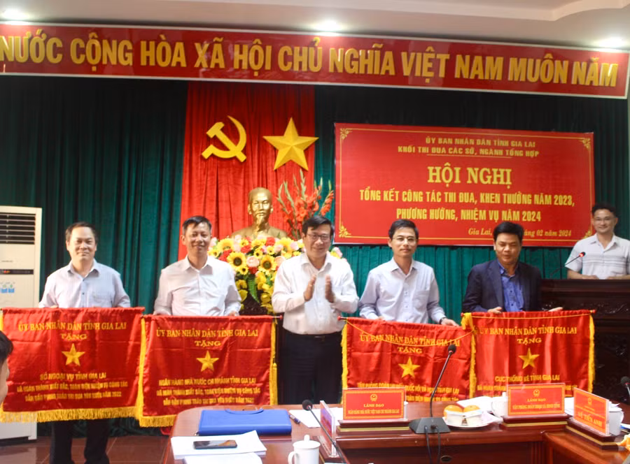 Thừa ủy quyền của Chủ tịch UBND tỉnh, đồng chí Trương Quang Tịnh-Trưởng Ban Thi đua-Khen thưởng tỉnh trao cờ thi đua cho các tập thể. Ảnh P.L