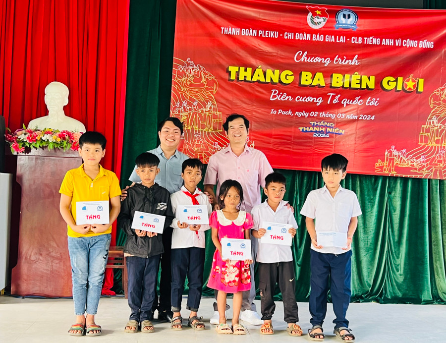 Phó Tổng Biên tập Đoàn Minh Dưỡng (hàng sau, bên phải) và anh Trương Chấn Sang-Chủ nhiệm Câu lạc bộ Tiếng Anh vì cộng đồng tỉnh Bình Dương tặng học bổng cho các em thiếu nhi khó khăn của xã Ia Púch. . Ảnh: P.L Phó Tổng Biên tập Đoàn Minh Dưỡng (hàng sau, bên phải) và anh Trương Chấn Sang-Chủ nhiệm Câu lạc bộ Tiếng Anh vì cộng đồng tỉnh Bình Dương tặng học bổng cho các em thiếu nhi khó khăn của xã Ia Púch. . Ảnh: P.L