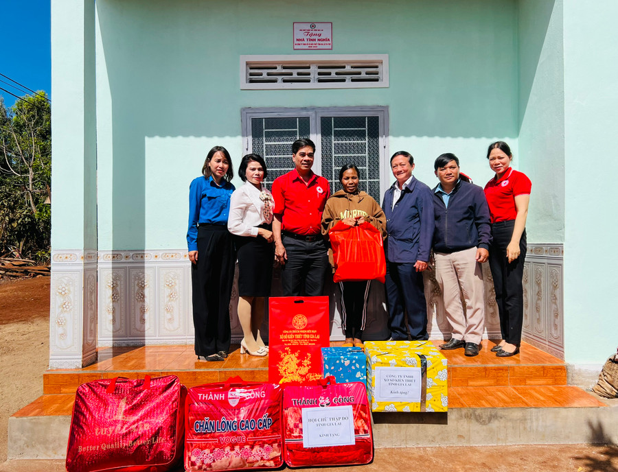 Các đơn vị bàn giao nhà và tặng quà cho bà Hẽm (ở giữa). Ảnh: P.L