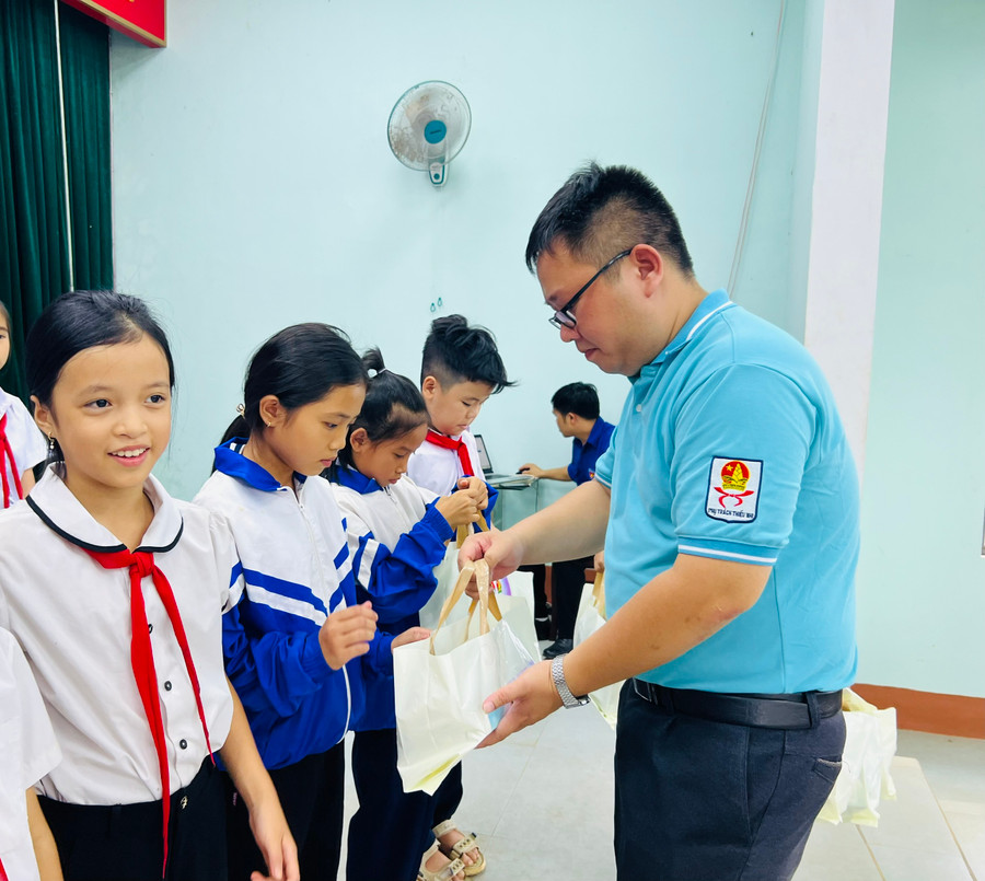 Anh Nguyễn Chí Hiếu-Phó Chủ tịch Thường trực Hội đồng Đội tỉnh tặng quà cho thiếu nhi khó khăn. Ảnh: M.N
