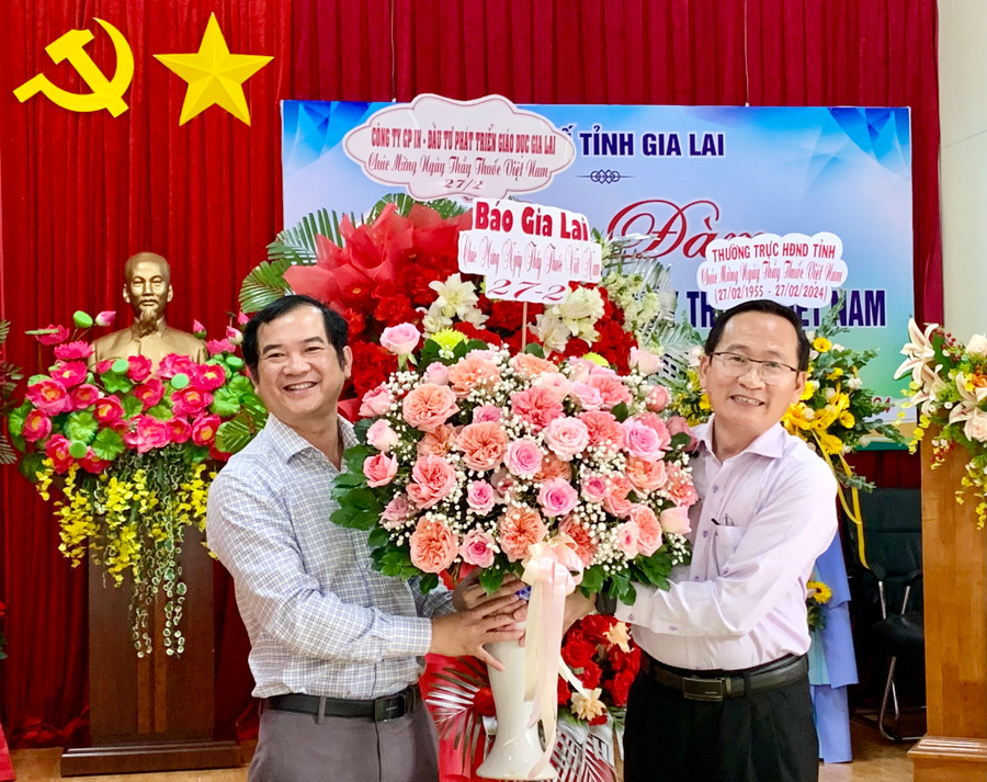 Phó Tổng Biên tập Báo Gia Lai Đoàn Minh Dưỡng (bìa trái) tặng hoa chúc mừng Sở Y tế. Ảnh: Như Nguyện