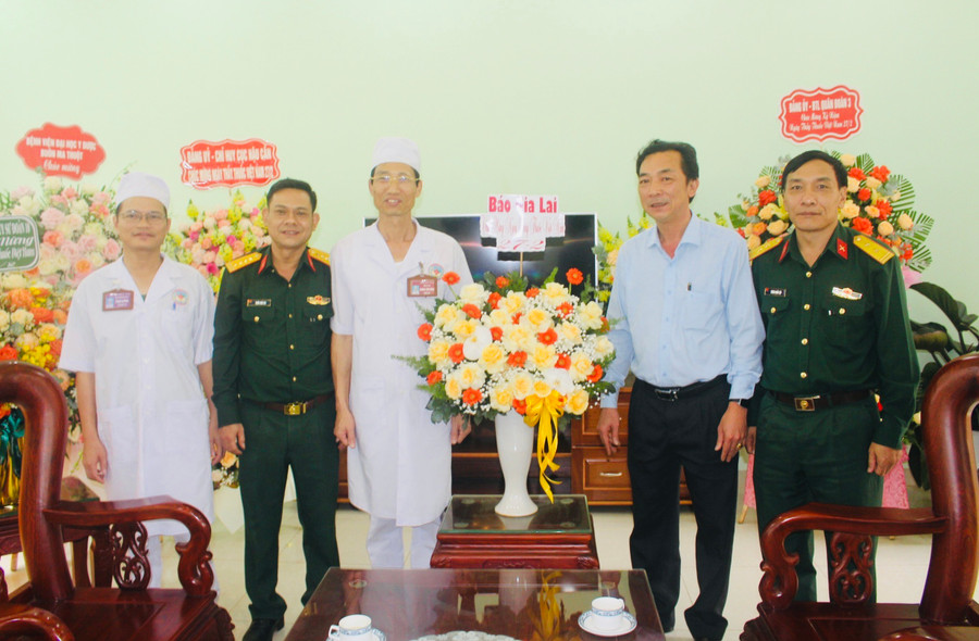 Phó Tổng Biên tập Báo Gia Lai Lương Văn Danh (thứ 2 từ phải qua) tặng hoa chúc mừng Bệnh viện Quân y 211. Ảnh: Phan Lài
