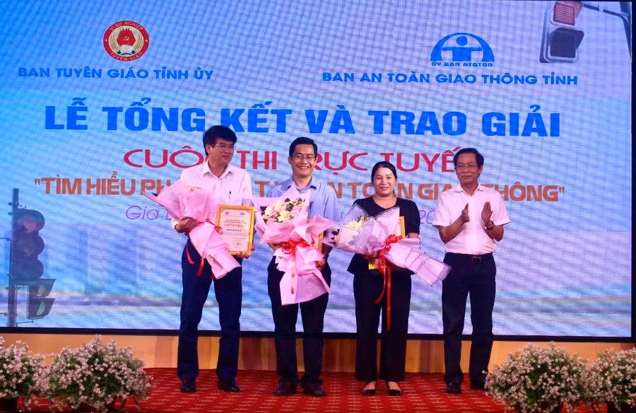 Phó Trưởng ban Thường trực Ban Tuyên giáo Tỉnh ủy Đỗ Tiến Đông (bìa phải) trao giải cho các tập thể đạt giải cuộc thi trực tuyến "Tìm hiểu pháp luật về an toàn giao thông". Ảnh: P.L