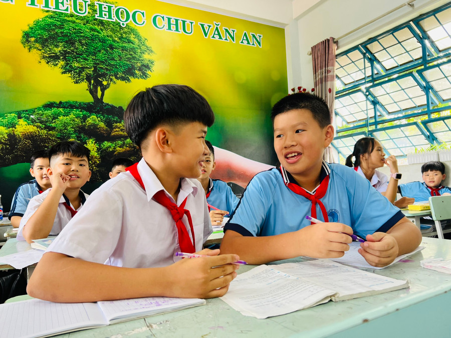 Em Vũ Hoàng Nam (bìa phải) luôn cởi mở, chia sẻ kiến thức Toán học cho các bạn cùng lớp. Ảnh: M.N