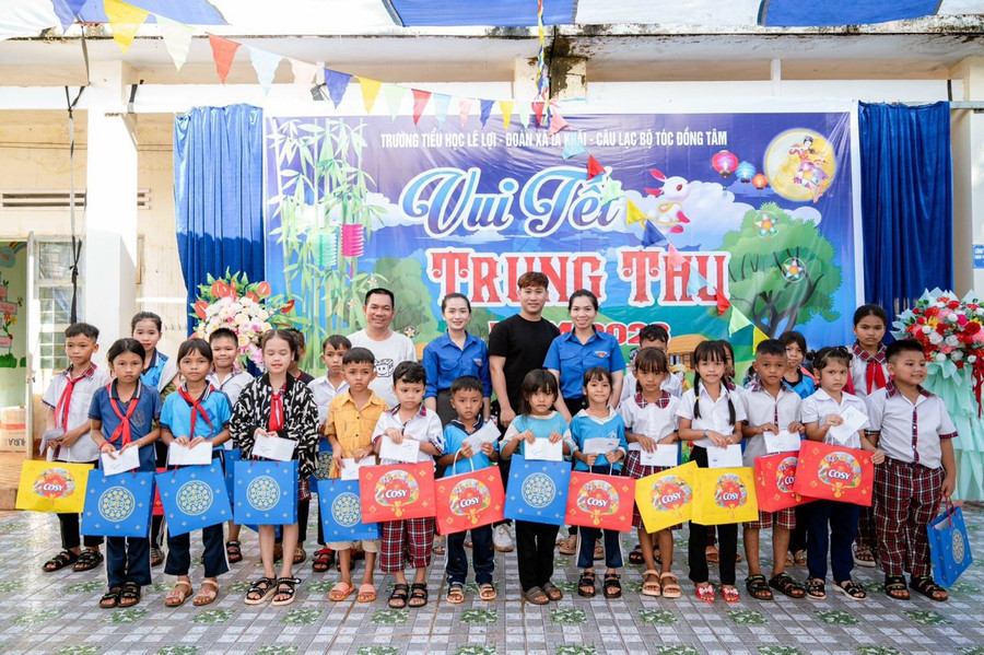 Chị Rơ Châm Byich (hàng sau, thứ 5 từ phải sang) kết nối nguồn lực tặng quà cho thiếu nhi khó khăn. Ảnh: M.N