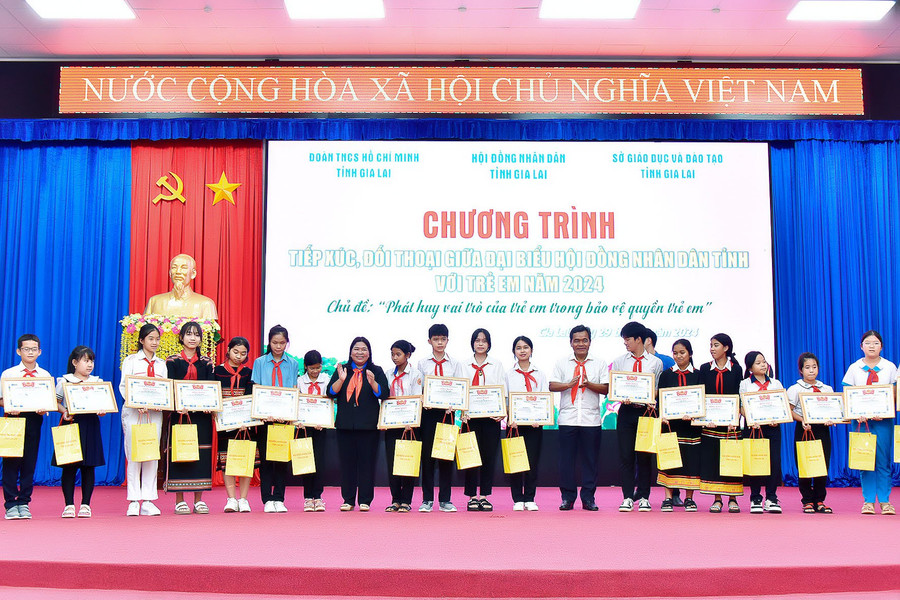 Bí thư Tỉnh ủy, Chủ tịch HĐND tỉnh Hồ Văn Niên (thứ 7 từ phải sang) cùng Bí thư Tỉnh Đoàn Hà Thị Giang Thảo (thứ 8 từ trái sang) tặng quà thiếu nhi tiêu biểu. Ảnh: Đ.T