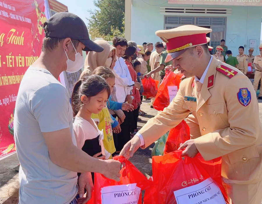 Thượng úy Nguyễn Hữu Hiếu (bìa phải) tặng quà cho người dân và thiếu nhi khó khăn. Ảnh: H.H