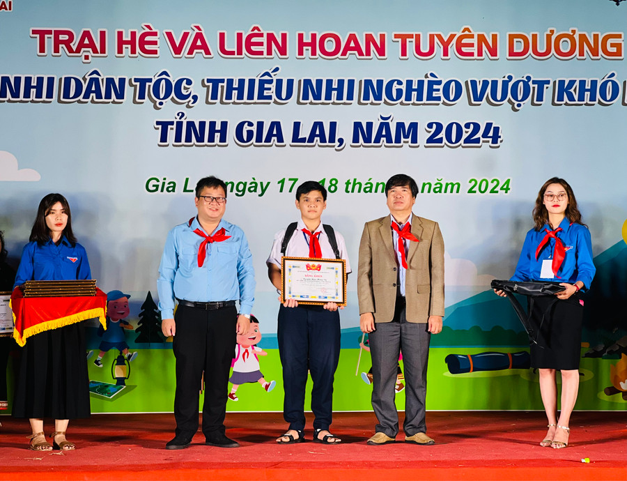 Các đại biểu trao bằng khen của Ban Chấp hành Tỉnh Đoàn cho thiếu nhi vượt khó học tốt. Ảnh: P.L