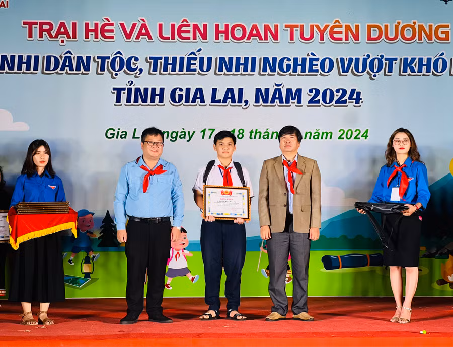 Các đại biểu trao bằng khen của Ban Chấp hành Tỉnh Đoàn cho thiếu nhi vượt khó học tốt. Ảnh: P.L