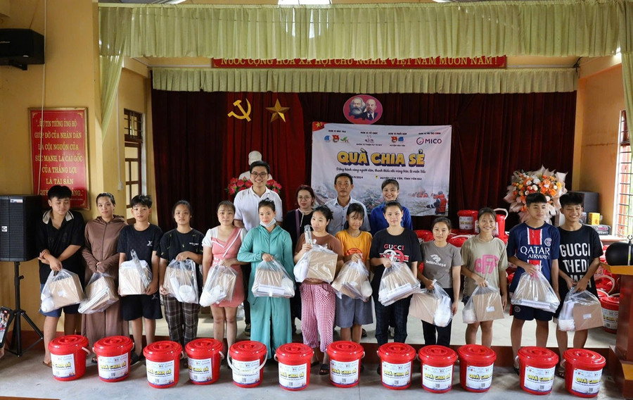 Anh Lê Văn Phúc (hàng sau, bìa trái) tặng quà người dân và thiếu nhi ở huyện Văn Yên (tỉnh Yên Bái). Ảnh: NVCC