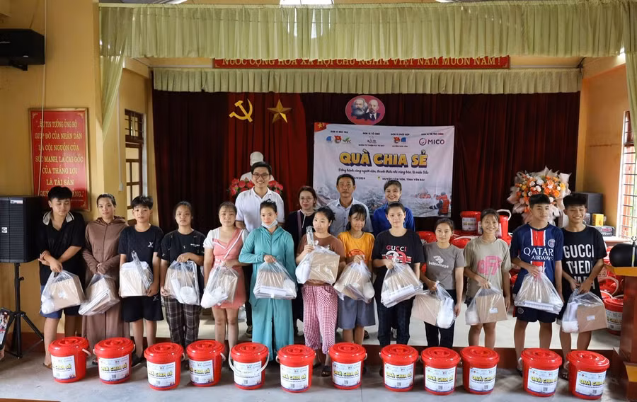 Anh Lê Văn Phúc (hàng sau, bìa trái) tặng quà người dân và thiếu nhi ở huyện Văn Yên (tỉnh Yên Bái). Ảnh: NVCC