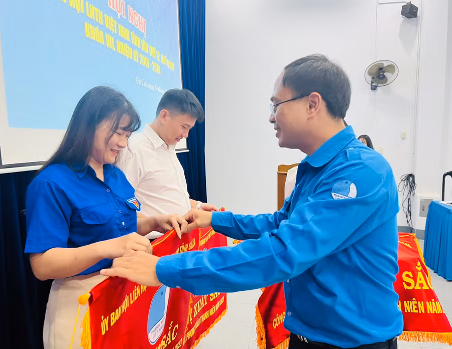 Anh Đỗ Đức Thanh-Phó Bí thư Tỉnh Đoàn, Chủ tịch Hội LHTN Việt Nam tỉnh tặng cờ thi đua đơn vị xuất sắc cho các tập thể. Ảnh: P.L