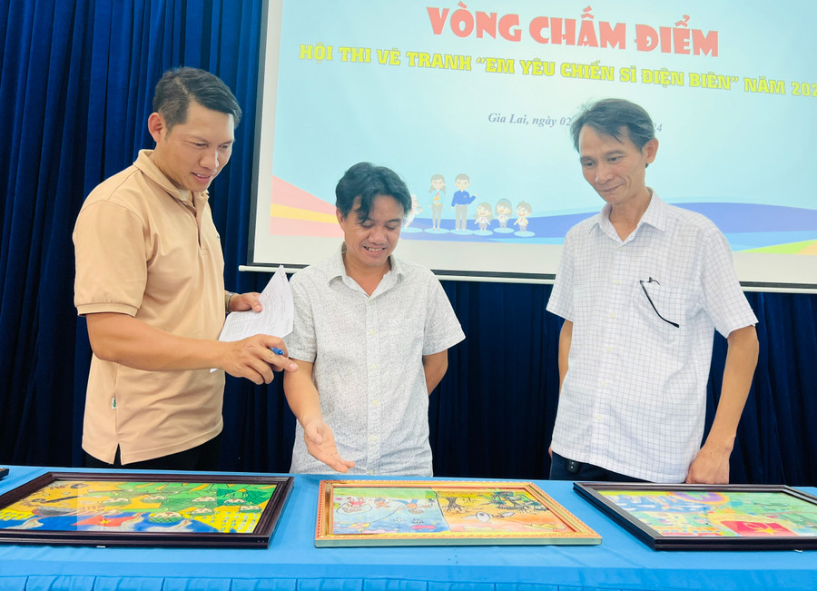 Ban giám khảo chấm điểm các bức tranh tham gia cuộc thi. Ảnh: M.N