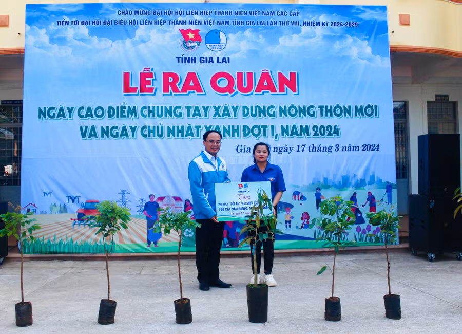 Anh Đỗ Đức Thanh (bìa trái)-Phó Bí thư Tỉnh Đoàn, Chủ tịch Hội LHTN Việt Nam tỉnh tặng mô hình đổi rác thải nhựa lấy cây xanh cho Đoàn xã Ia Nhin. Ảnh: P.L