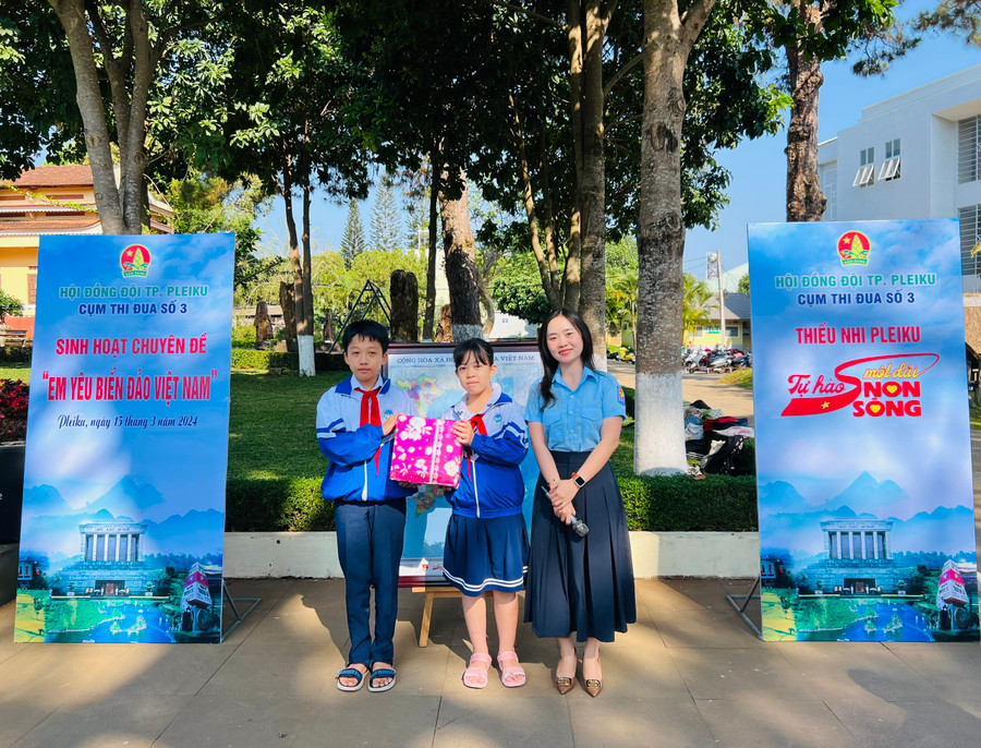 Ban tổ chức trao giải nhất cuộc thi Rung chuông vàng cho 2 đội viên Trường Tiểu học Nguyễn Văn Trỗi. Ảnh: M.N