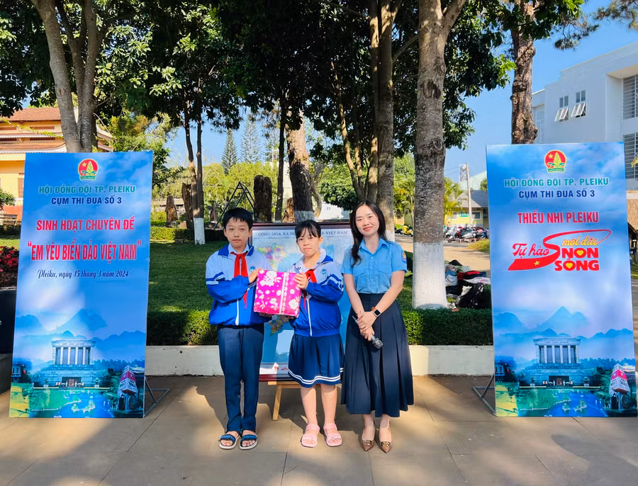 Ban tổ chức trao giải nhất cuộc thi Rung chuông vàng cho 2 đội viên Trường Tiểu học Nguyễn Văn Trỗi. Ảnh: M.N