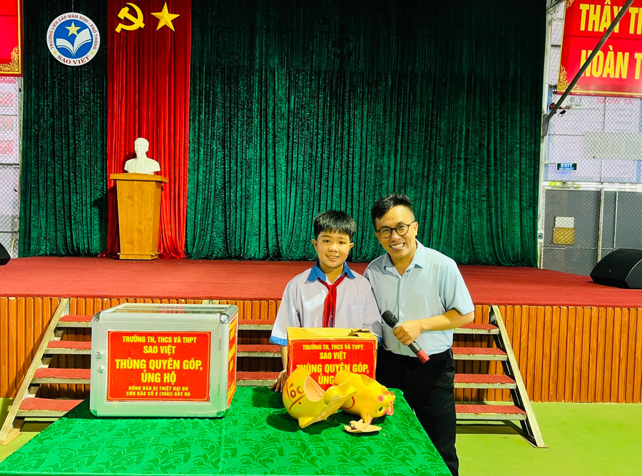 Em Nguyễn Khải Hòa (bìa trái)-Truờng Tiểu học, THCS và THPT Sao Việt đập heo đất ủng hộ đồng bào vùng bão lũ. Ảnh: P.L Em Nguyễn Khải Hòa (bìa trái)-Truờng Tiểu học, THCS và THPT Sao Việt đập heo đất ủng hộ đồng bào vùng bão lũ. Ảnh: P.L