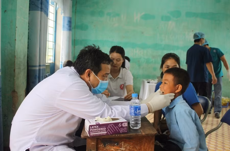 Bác sĩ khám răng cho thiếu nhi xã Ia Kdăm. Ảnh: Phan Vũ