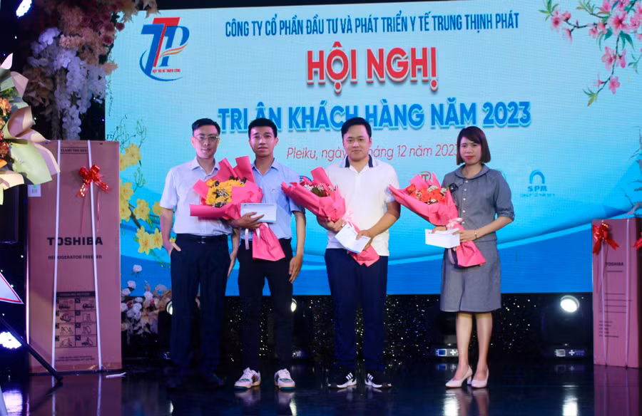 Ông Trần Thanh Bình (bìa trái)-Giám đốc Công ty tặng hoa các khách hàng có doanh số cao nhất năm 2023. Ảnh: M.N