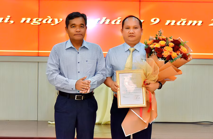 Bí thư Tỉnh ủy Hồ Văn Niên (bìa trái) trao quyết định và tặng hoa chúc mừng đồng chí Rah Lan Chung. Ảnh: Đức Thụy