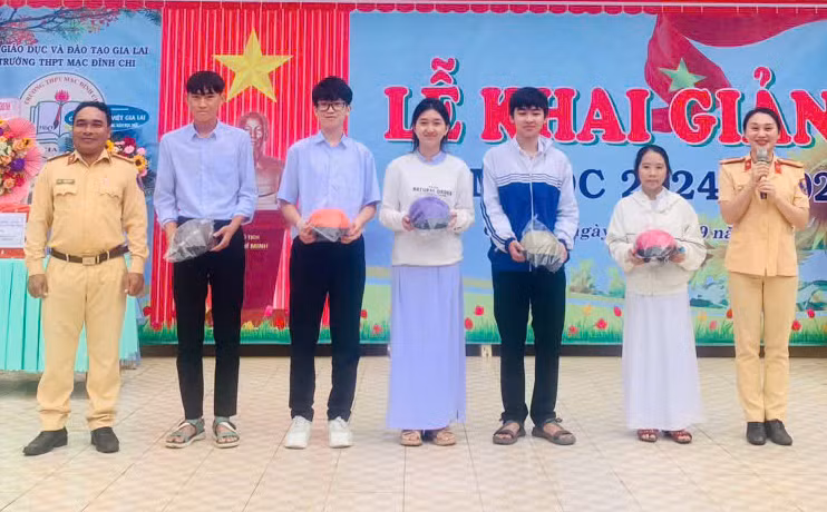 Đội Cảnh sát giao thông-Trật tự (Công an huyện Chư Păh) tặng mũ bảo hiểm cho các em học sinh Trường THPT Mạc Đĩnh Chi. Ảnh: V.Đ