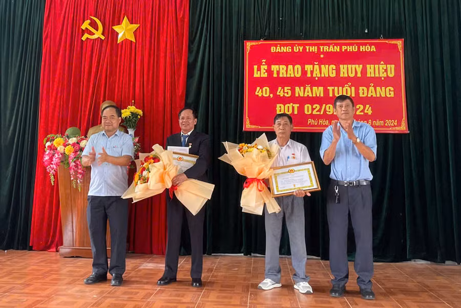 Ông Nguyễn Văn Ánh-Trưởng ban Tổ chức Huyện ủy Chư Păh (bìa trái) trao Huy hiệu Đảng cho các đảng viên thuộc Đảng bộ thị trấn Phú Hòa. Ảnh: V.Đ
