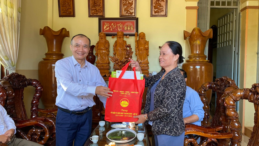 Thừa ủy quyền của Ban Thường vụ Tỉnh ủy, đồng chí Huỳnh Minh Thuận-Tỉnh ủy viên, Bí thư Đảng ủy Khối các cơ quan và doanh nghiệp tỉnh trao tặng quà của tỉnh cho các gia đình thương binh, chính sách. Ảnh: Sơn Ca.