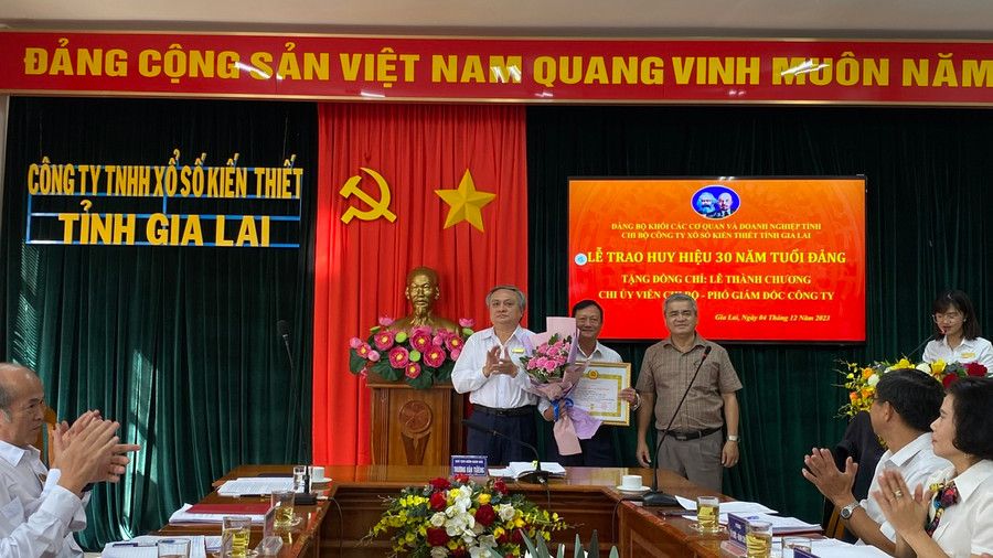 Đồng chí Dương Dã-Phó Bí thư Thường trực Đảng ủy Khối và đồng chí Trương Văn Thiêng-Bí thư Chi bộ, Chủ tịch kiêm Giám đốc Công ty chúc mừng đồng chí Lê Thành Chương. Ảnh: Sơn Ca