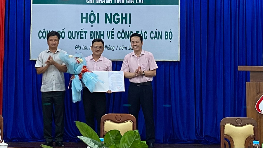 Ông Nguyễn Hữu Quế-Phó Chủ tịch UBND tỉnh, Trưởng ban đại diện và ông Hoàng Minh Tế-Phó Tổng Giám đốc Ngân hàng Chính sách Xã hội Việt Nam trao quyết định, tặng hoa chúc mừng tân Phó Giám đốc Chi nhánh. Ảnh: Sơn Ca.