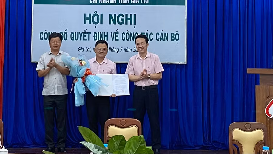Ông Nguyễn Hữu Quế-Phó Chủ tịch UBND tỉnh, Trưởng ban đại diện và ông Hoàng Minh Tế-Phó Tổng Giám đốc Ngân hàng Chính sách Xã hội Việt Nam trao quyết định, tặng hoa chúc mừng tân Phó Giám đốc Chi nhánh. Ảnh: Sơn Ca.