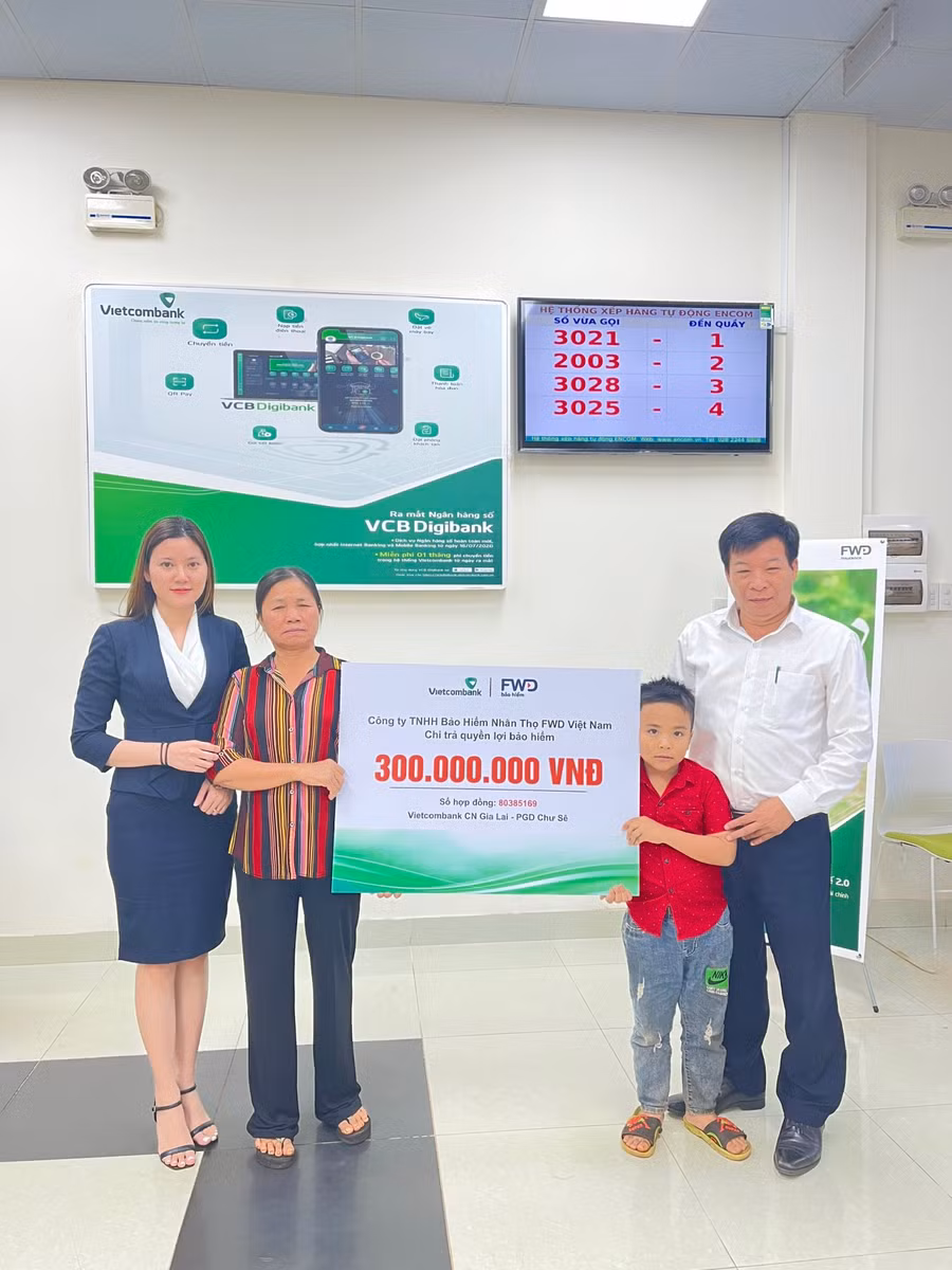 Đại diện lãnh đạo Phòng giao dịch Chư Sê-Vietcombank Chi nhánh Gia Lai phối hợp với FWD Việt Nam chi trả bồi thường cho gia đình khách hàng. Ảnh: Sơn Ca