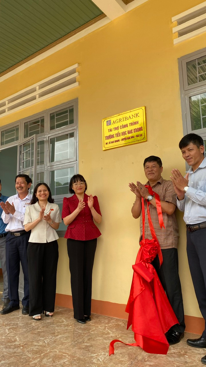 Bà Nguyễn Thị Mai Phương và lãnh đạo huyện Đak Đoa gắn biển công trình tài trợ tại Trường Tiểu học Đak Krong. Ảnh: Sơn Ca.