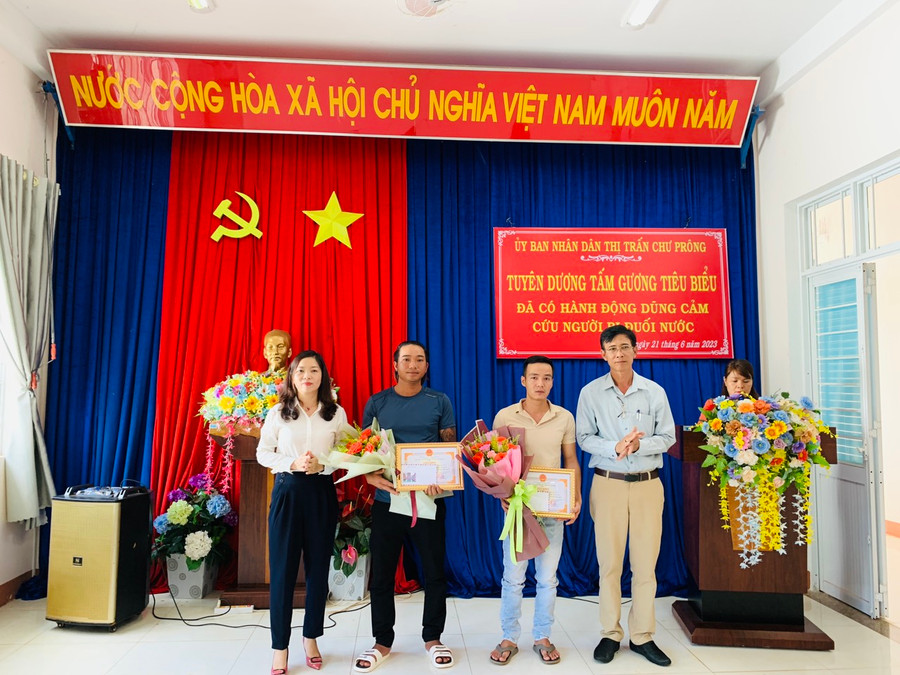 Ông Trần Hiếu (bìa phải)-Chủ tịch UBND thị trấn Chư Prông tặng giấy khen cho anh Đỗ Đình Huấn (thứ 2 từ phải qua) và anh Nguyễn Văn Bá (thứ 3 từ phải qua). Ảnh: Ngọc Linh