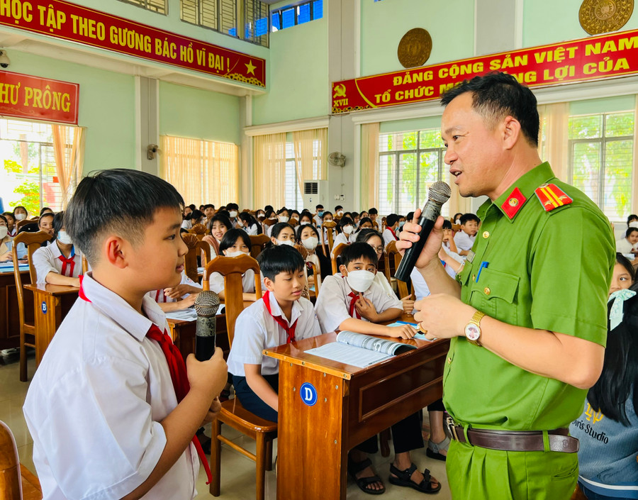 Trung tá Nguyễn Đình Cường (Công an huyện Chư Prông) hướng dẫn các em thiếu nhi cách nhận biết bị xâm hại. Ảnh: Phan Lài