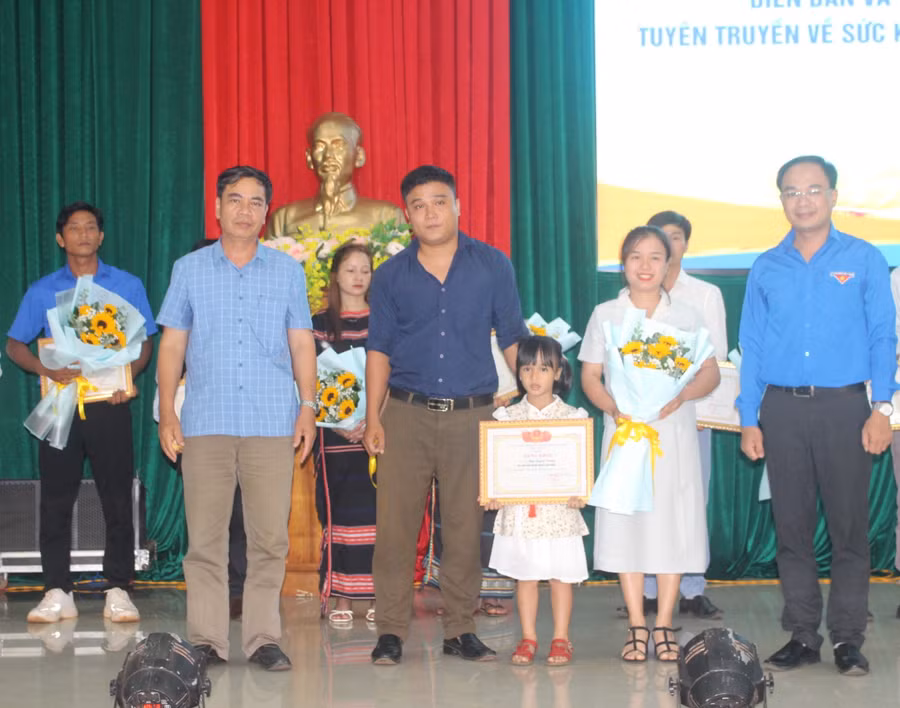 Anh Đỗ Đức Thanh (bìa phải)-Phó Bí thư Tỉnh Đoàn, Chủ tịch Hội LHTN Việt Nam tỉnh và Phó Chủ tịch UBND huyện Chư Prông Ksor Việt (hàng trước, bìa trái) tặng bằng khen cho gia đình trẻ tiêu biểu. Ảnh: P.L