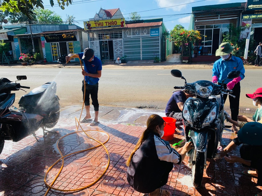 Đoàn viên, thanh niên thị trấn Chư Prông (huyện Chư Prông) tham gia hoạt động rửa xe gây quỹ. Ảnh: Phan Lài