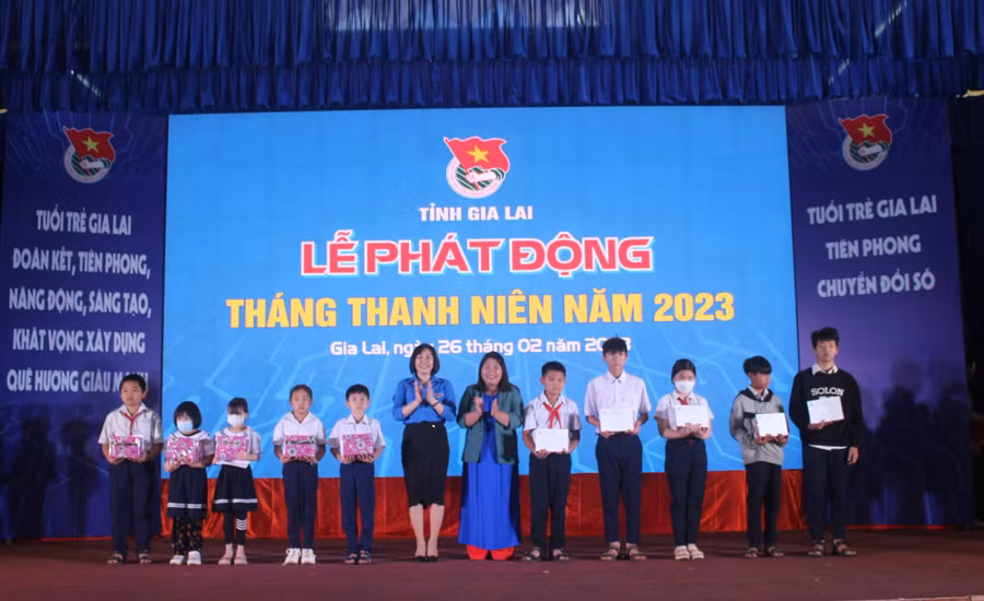 Phó Trưởng ban Dân vận Vũ Thị Thu (thứ 6 từ trái qua) và Bí thư Tỉnh Đoàn Hà Thị Giang Thảo (thứ 6 từ phải qua) tặng quà cho học sinh khó khăn ở TP. Pleiku. Ảnh: Phan Lài