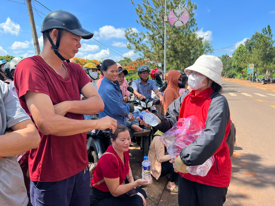 Các tình nguyện viên của huyện Đức Cơ phát nước miễn phí cho người nhà thí sinh tại điểm thi Trường THPT Lê Hoàn (huyện Đức Cơ). Ảnh: Phan Lài