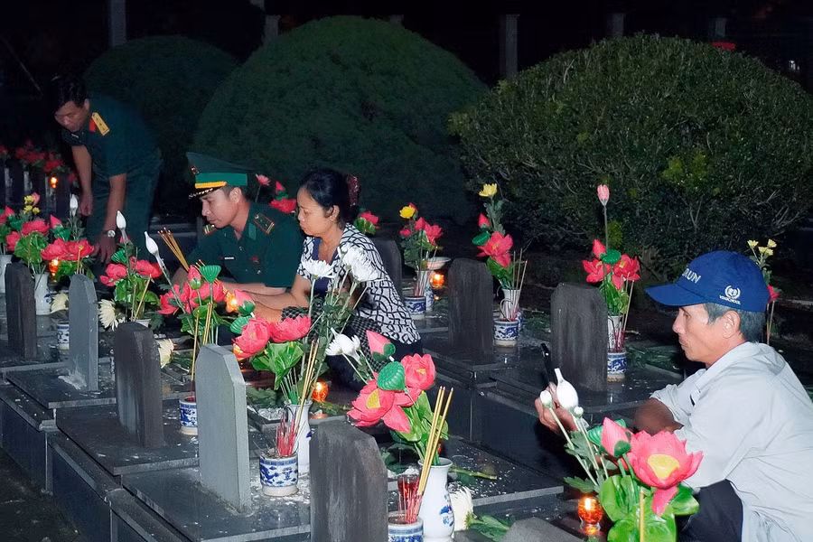 Người dân và các cán bộ, chiến sĩ dâng hương tại phần mộ các liệt sĩ. Ảnh: Đ.T