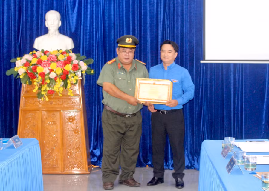 Thừa ủy quyền của Bộ trưởng Bộ Công an, Thượng tá Krung Dăm Vực (bìa trái)-Phó Trưởng Phòng An ninh chính trị nội bộ (Công an tỉnh) tặng bằng khen cho cơ quan Tỉnh Đoàn Gia Lai. Ảnh: P.L