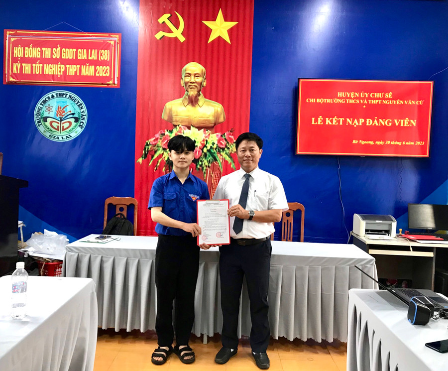 Thầy Trương Quang Phong (bìa phải)-Bí thư Chi bộ, Hiệu trưởng Trường THCS và THPT Nguyễn Văn Cừ trao quyết định kết nạp Đảng cho đảng viên mới Đới Sĩ Hoàng Long. Ảnh: Nguyễn Quân Thầy Trương Quang Phong (bìa phải)-Bí thư Chi bộ, Hiệu trưởng Trường THCS và THPT Nguyễn Văn Cừ trao quyết định kết nạp Đảng cho đảng viên mới Đới Sĩ Hoàng Long. Ảnh: Nguyễn Quân