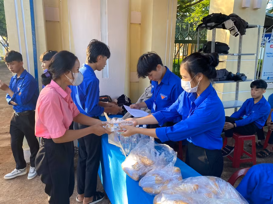 Các tình nguyện viên phát đồ ăn sáng miễn phí tại điểm thi Trường THPT Nguyễn Bỉnh Khiêm (huyện Chư Sê). Ảnh: Ngọc Sang