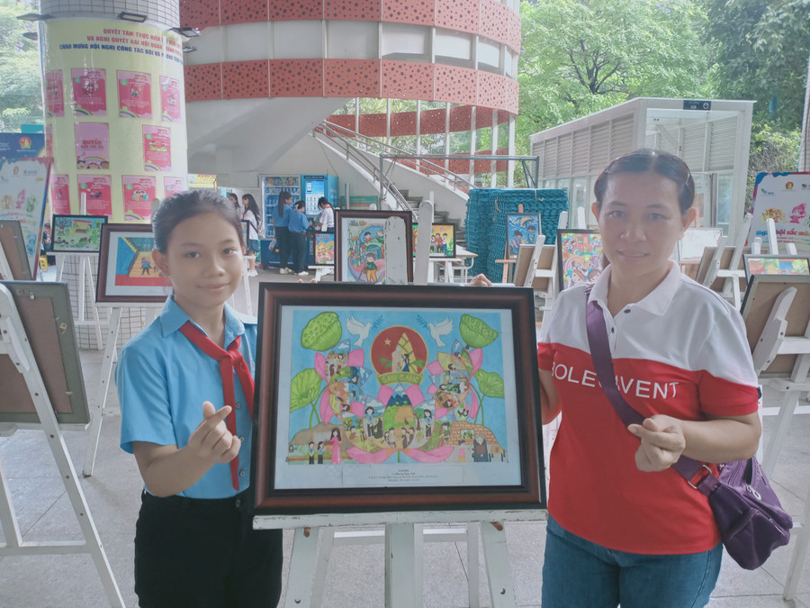 Em Dương Ngọc Ánh (bìa trái) bên bức tranh "Hoa nghìn việc tốt" đạt giải ba tại cuộc thi vẽ tranh do Hội đồng Đội Trung ương tổ chức. Ảnh: Đinh Đan Em Dương Ngọc Ánh (bìa trái) bên bức tranh "Hoa nghìn việc tốt" đạt giải ba tại cuộc thi vẽ tranh do Hội đồng Đội Trung ương tổ chức. Ảnh: Đinh Đan