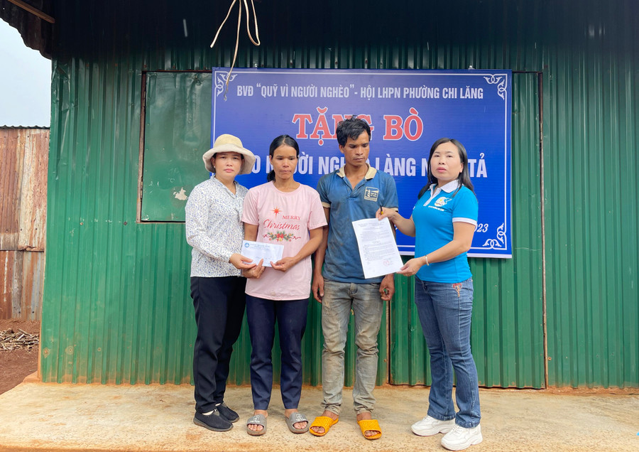 Đại diện Hội LHPN phường Chi Lăng và Ban vận động “Quỹ vì người nghèo” của phường trao quyết định tặng bò sinh sản cho gia đình chị H’Mlim (làng Ngol Tả). Ảnh: Phạm Ngọc