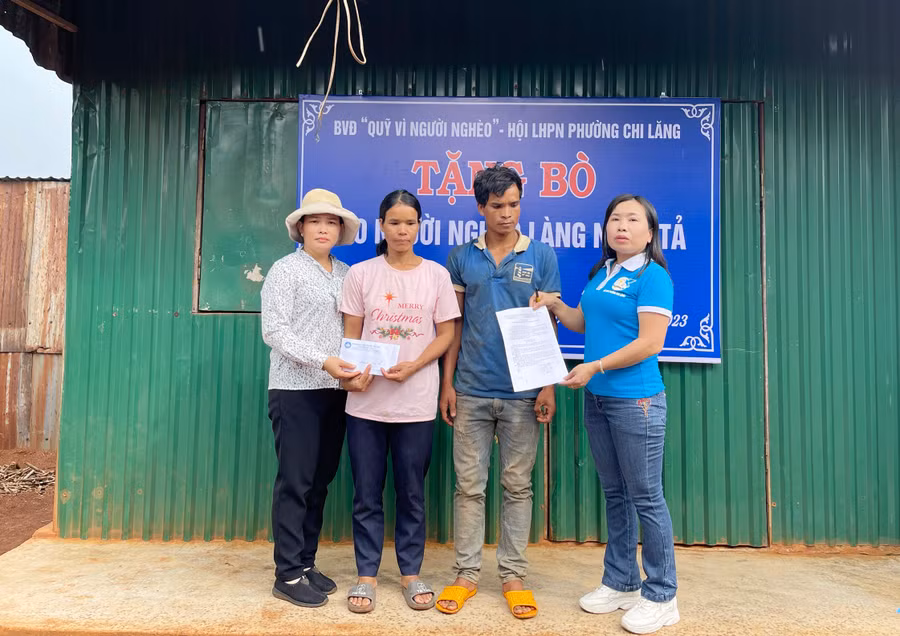 Đại diện Hội LHPN phường Chi Lăng và Ban vận động “Quỹ vì người nghèo” của phường trao quyết định tặng bò sinh sản cho gia đình chị H’Mlim (làng Ngol Tả). Ảnh: Phạm Ngọc