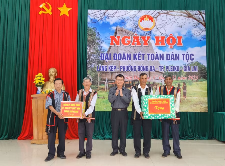 Bí thư Thành ủy Pleiku Trịnh Duy Thuân tặng quà của Tỉnh ủy, HĐND, UBND, Ủy ban MTTQ Việt Nam tỉnh và TP. Pleiku cho cán bộ và người dân làng Kép. Ảnh: Ngọc Sang