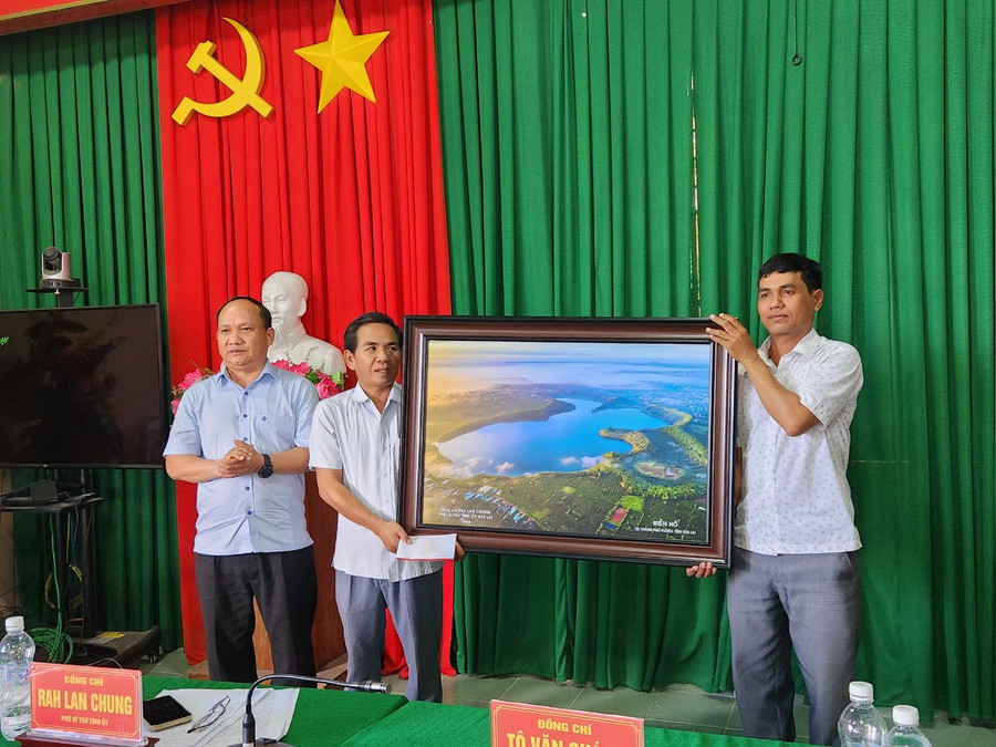 Phó Bí thư Tỉnh ủy Rah Lan Chung (bìa phải) tặng quà cho Đảng bộ xã Krông Năng. Ảnh: Ngọc Sang