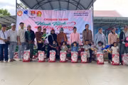 Ban Tổ chức tặng quà cho các em thiếu nhi có hoàn cảnh khó khăn buôn Đất Bằng. Ảnh: Vũ Chi
